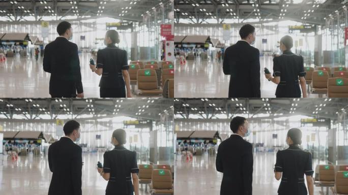 两名乘务员的后视图，带着旅行杯零浪费想法走在一起，然后在机场门口加入另一个队友-股票视频