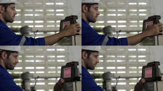 男工程师在工业机械组件中组装后检查机器的准备情况。