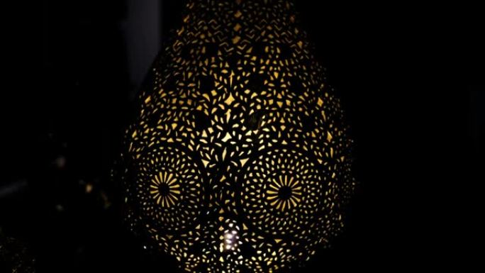 带有复杂花卉图案的点灯摩洛哥阿拉伯黄铜灯的抽象特写。