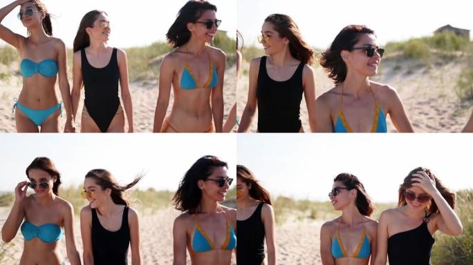 一群漂亮的女性朋友穿着泳衣在热带沙滩上散步很开心。夏季户外聊天和大笑的跨种族女性。海边穿着比基尼和泳