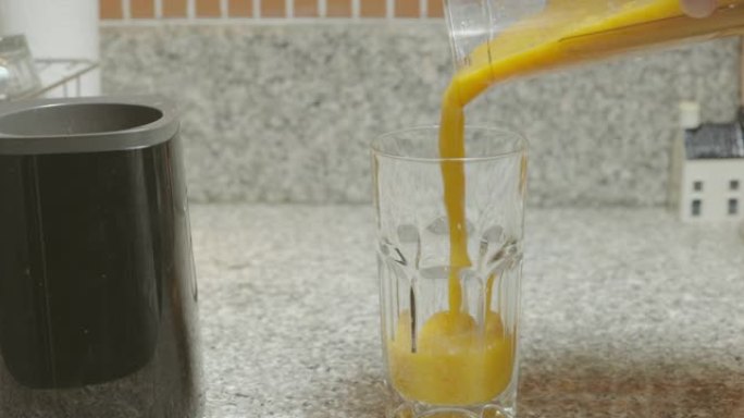 SLO MO混合水果冰沙流落入充满泡沫牛奶的玻璃杯中。