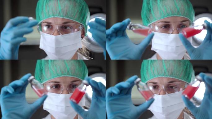 集中的女性研究员在防护手套，面罩和眼镜上拿着两瓶有效的抗感染疫苗，化学家在医院实验室与微生物合作，进