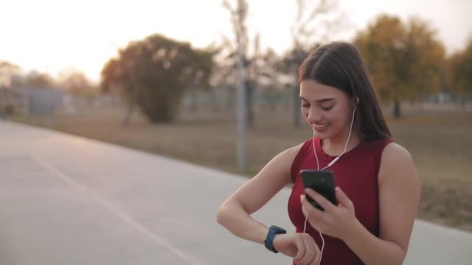 现代年轻女子用手机在慢跑运动中暂停。