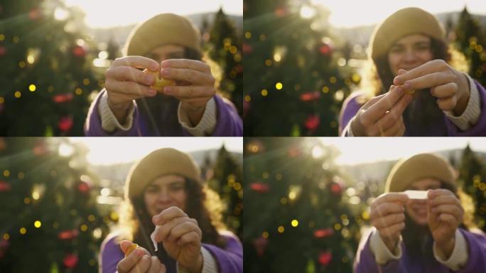 女人在模糊的圣诞树上打破幸运饼干