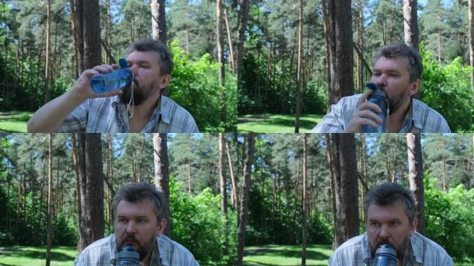 成熟的男人在森林里喝水