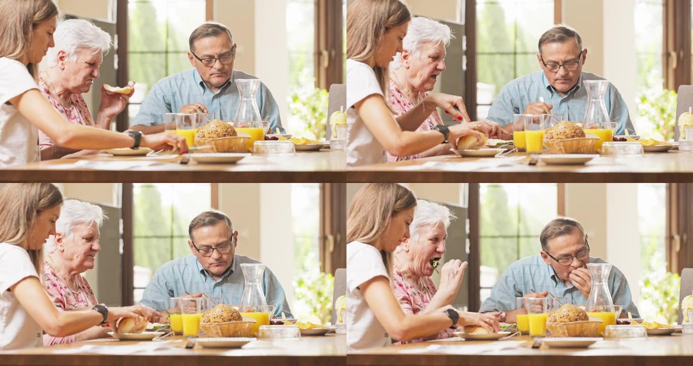 一家人正在吃早饭，父母坐在客厅里的桌子旁，他们的女儿坐在母亲旁边，他们正在准备食物，切面包，说话