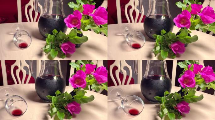 自制红酒在玻璃水罐，鲜花和酒杯在房间的白色桌子上