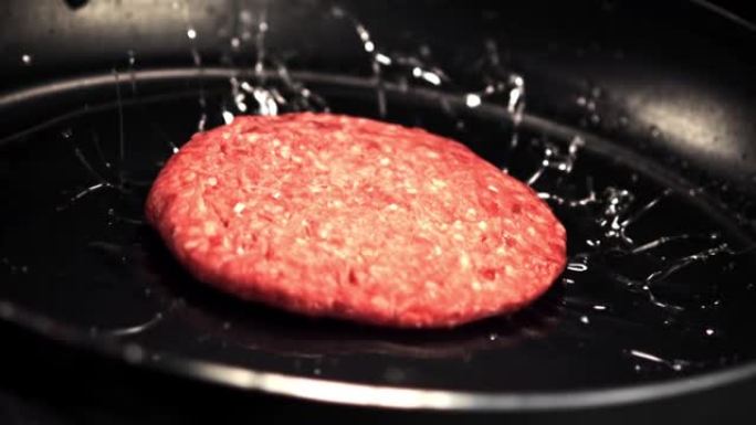 平底锅上的超级慢动作掉落了一个带有黄油的生汉堡。以1000 fps的高速相机拍摄。
