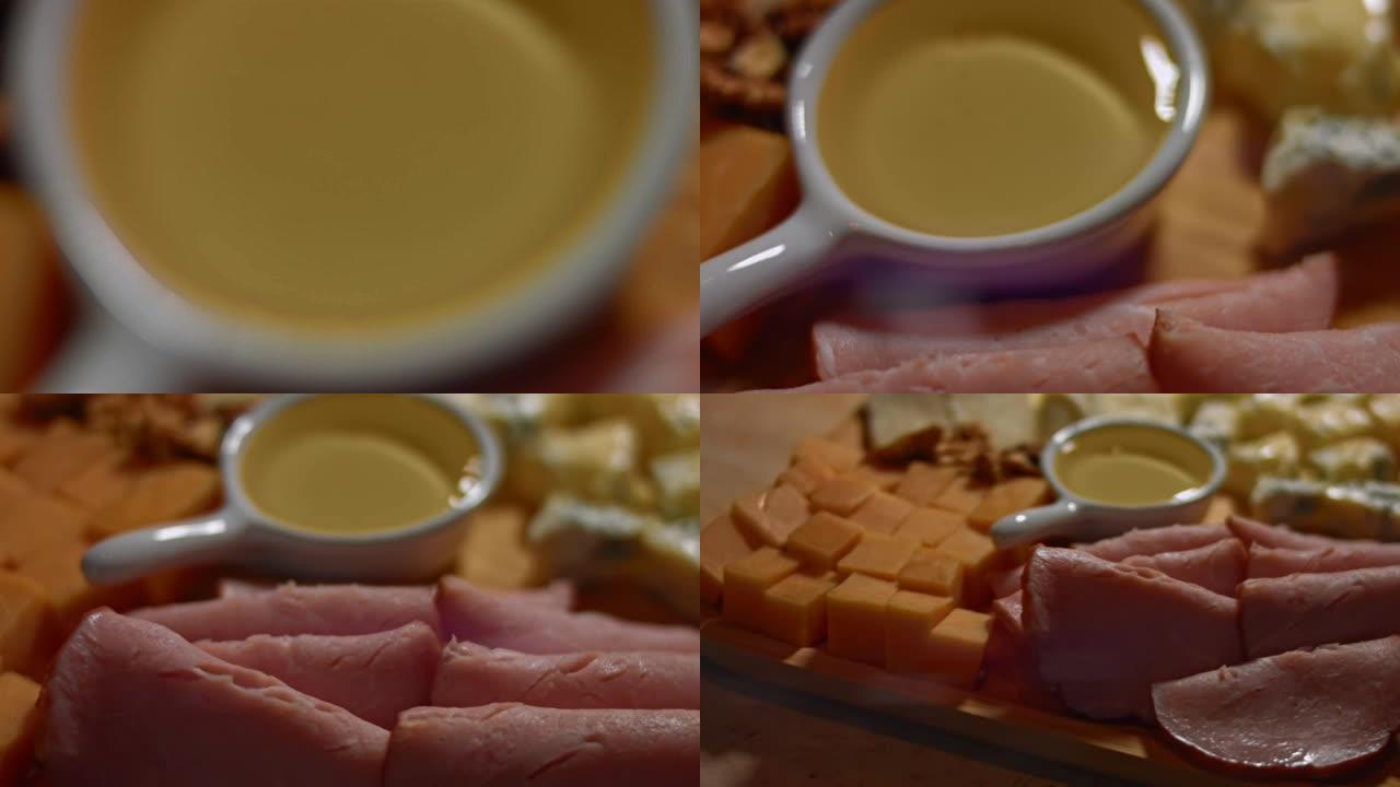 在木托盘上设置不同的奶酪，猪肉火腿，蜂蜜和希腊坚果。木托盘上的各种奶酪作为开胃菜。4k视频，慢动作