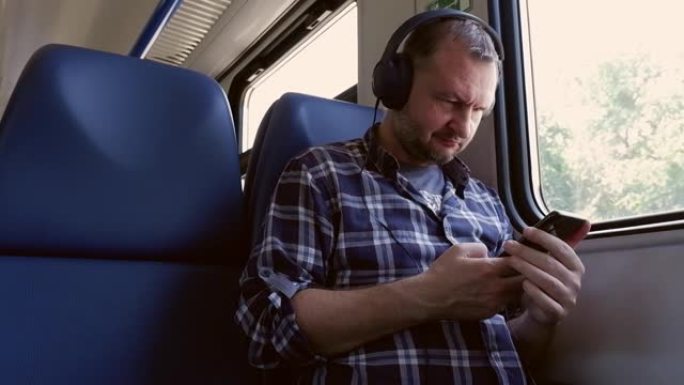 一名40岁的男子坐在火车上，戴着耳机听音乐。生活方式