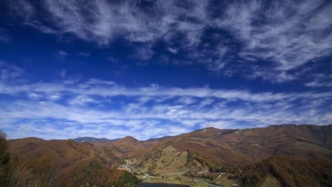 从山梨县乙女湖天文台流到蓝天和秋天色彩的山脉的云层