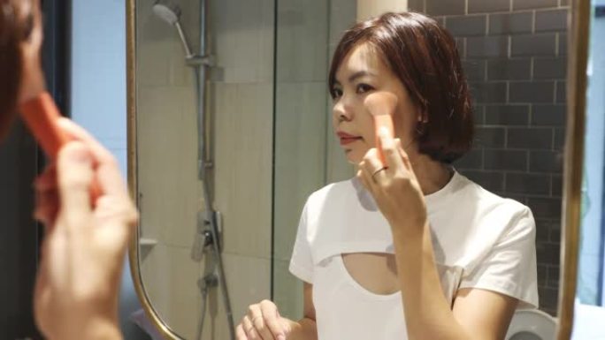 4K UHD年轻女性在厕所的镜子前化妆