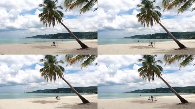 泰国普吉岛高清。热带海滩天堂，海滩秋千，白衬衫女孩。女人在美丽的热带海滩白色沙滩上的椰子棕榈树下摇摆