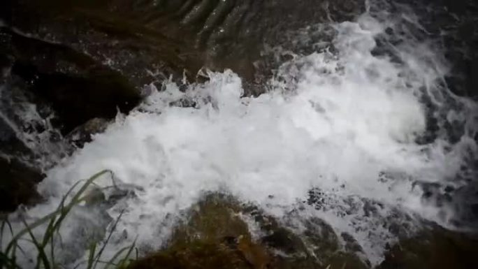 巨大的胆量在瀑布的底部，柔滑的水流在岩石中流动，美丽的风景与小山河上的瀑布，