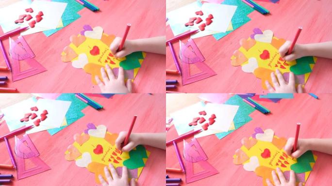 小女孩给奶奶做卡片。彩色粉色背景，纸质装饰，五彩心形。生日、母亲节和祖父母节的手工制作概念