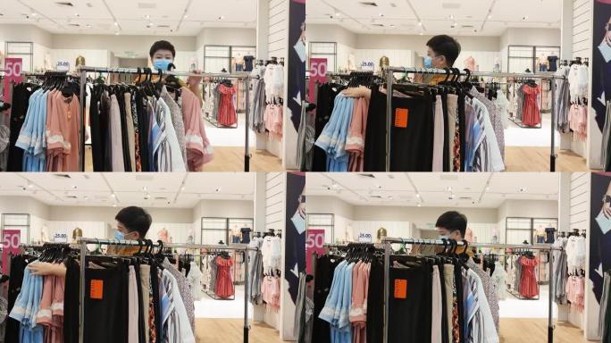 亚洲华人女性精品店服装店老板工作整理服装