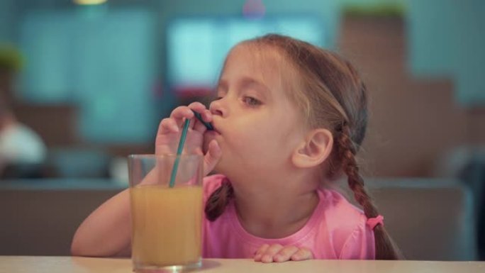 小女孩用吸管喝橙汁