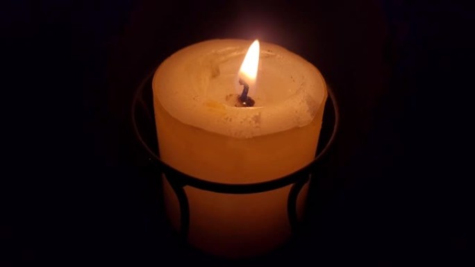 在黑色背景上点燃带有移动火焰的蜡烛，没有声音。水疗放松蜡烛，冥想蜡烛。芳香疗法蜡烛。