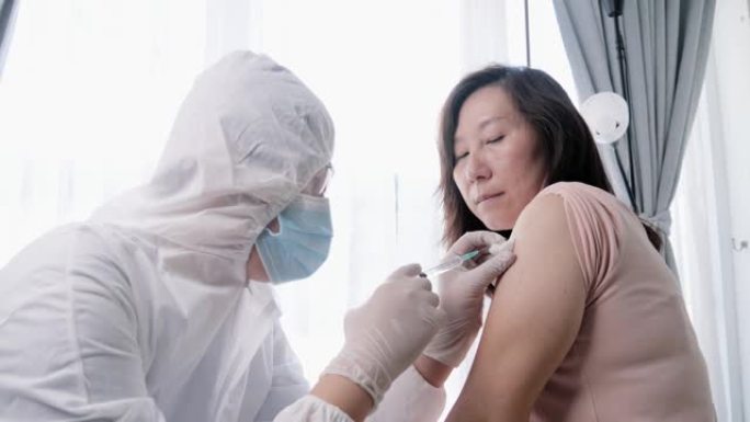 实验室工作人员在新型冠状病毒肺炎爆发期间向亚洲妇女注射电晕病毒疫苗