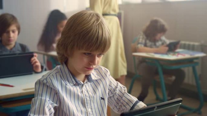 上课期间男孩在数字平板电脑的屏幕上看。学生用pad学习