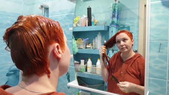 在家里自己染发，一个女人用鲜红色的染发