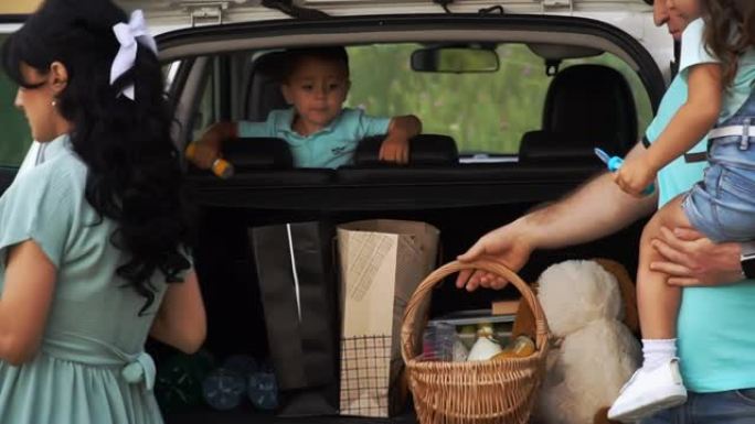 一家人开车去野餐，从slowmo的后备箱里卸下东西