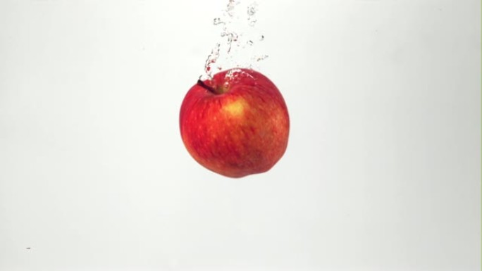 超级慢动作红色多汁的苹果落在有气泡的水下。以1000 fps的高速相机拍摄。
