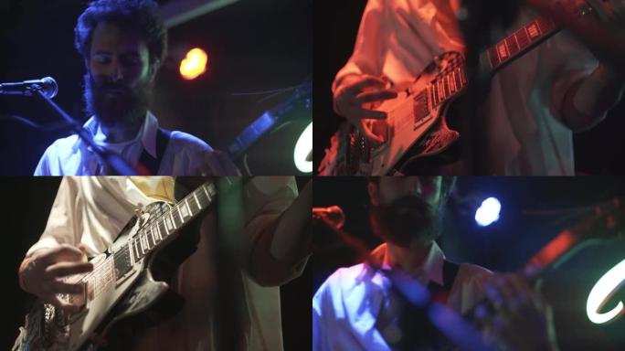 大胡子的年轻摇滚吉他手与他的乐队成员一起在舞台上表演，在聚光灯下近距离观看