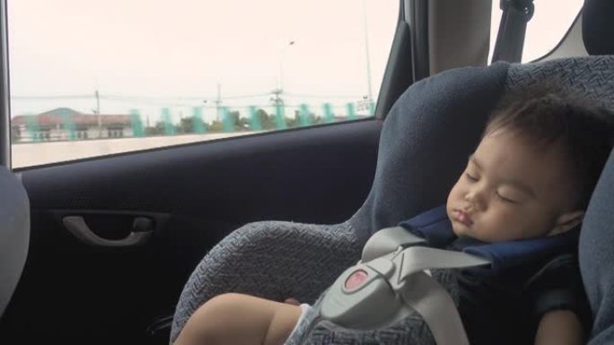 在安全儿童汽车座椅上睡在车内的男婴
