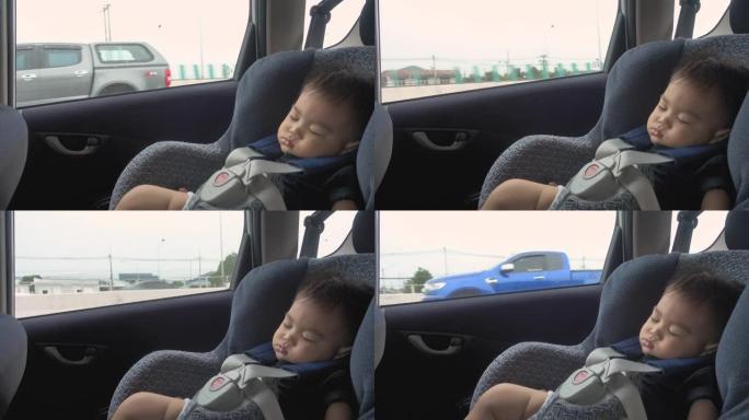在安全儿童汽车座椅上睡在车内的男婴