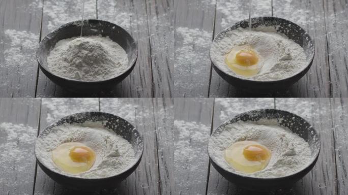 慢慢地将碎鸡蛋倒入一个装有面粉的老式木碗中。烹饪面团。黑魔法电影摄像机6K。