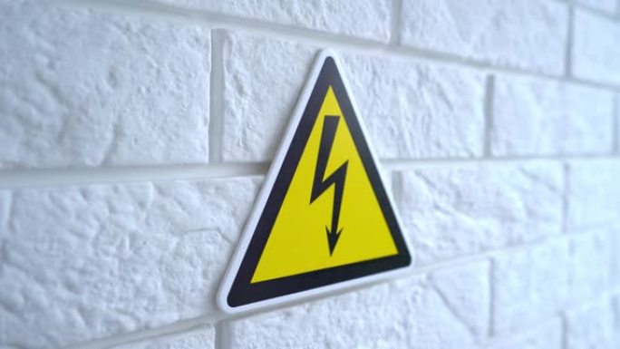 电危险黄色背景上的标志。危险标志挂在墙上。4k素材。
