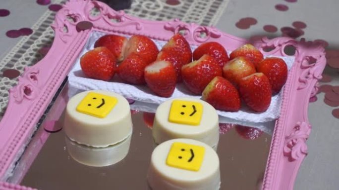 一盘草莓作为零食的特写镜头，并用手取出一个