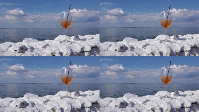 静态视图鸡尾酒酒杯在海边白石围栏与海浪背景
