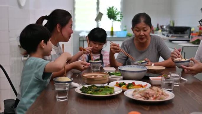 快乐的亚洲华人家庭在家里吃午饭