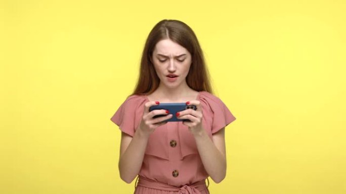 细心的女人急切地在手机上玩电子游戏。