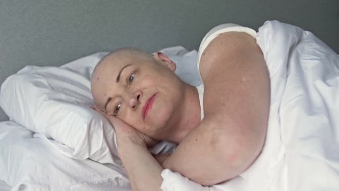 患有癌症的女性患者在另一疗程化疗后躺在患者的床上