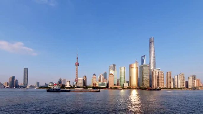 从外滩观看的上海天际线，具有蓝天背景的摩天大楼和地标，在黄浦江上航行的船只，延时4k镜头。