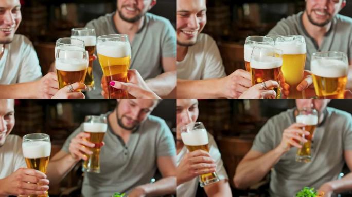慢动作特写快乐的年轻朋友一起在酒吧喝啤酒和碰杯玩得开心。友谊、节日、庆祝的概念