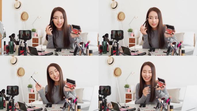 年轻美丽的亚洲女性职业美容影响者在家做化妆教程在线直播