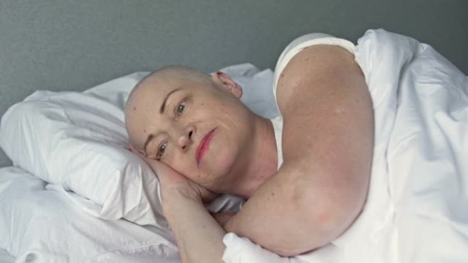 患有癌症的女性患者在另一疗程化疗后躺在患者的床上