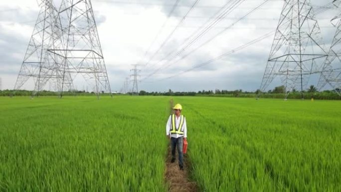 穿着特殊衣服的能源工程师使用平板电脑上的电子传感器数据检查电源线。