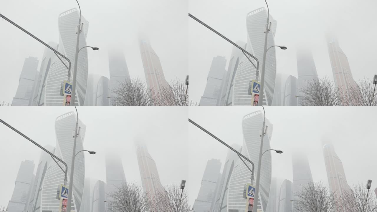 路灯和交通信号灯的底视图，背景是令人叹为观止的现代建筑合奏。行动。莫斯科市塔在一个大雾的日子
