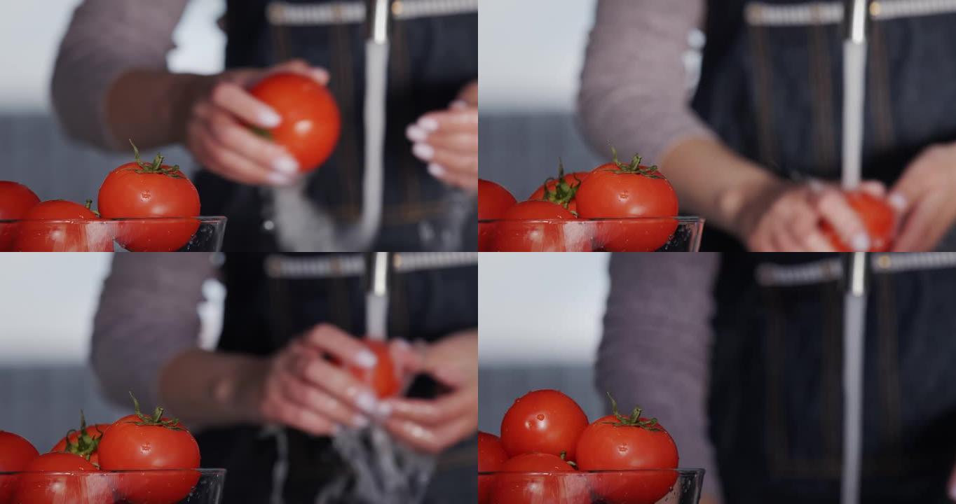 一碗西红柿，以女人的手为背景-在水龙头的水流下洗西红柿