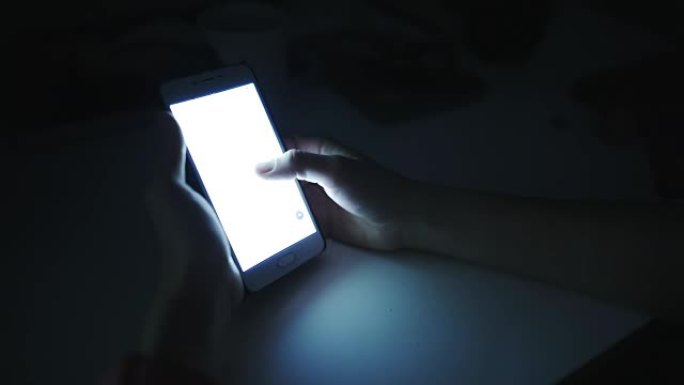 女人在黑暗的房间里使用智能手机