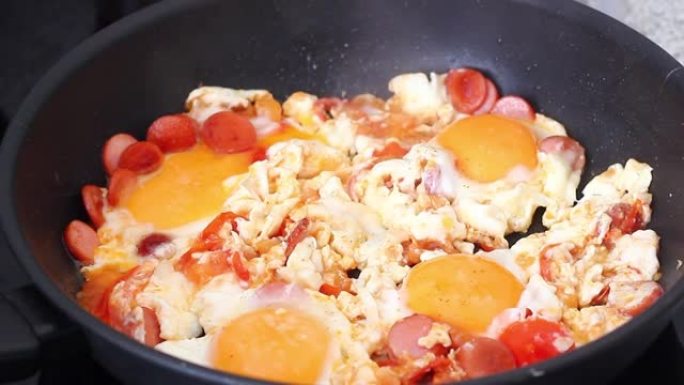 炒鸡蛋与香肠片和切碎的西红柿一起炒早餐
