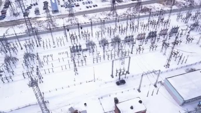 电力城变电站的俯视图。行动。带有变压器的变电站，在整个城市分配高压。冬季郊区变电站。电力工业