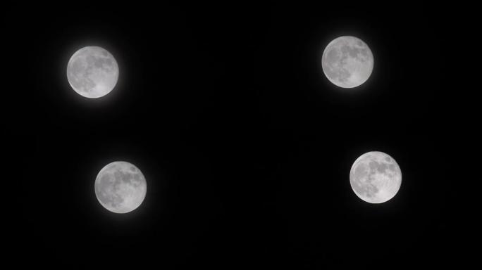 满月的延时镜头在夜空中移动，云层很轻。神秘的月亮从下到上移动。月光在黑色的夜空中闪耀，4k b滚动拍