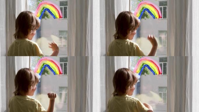 学龄前儿童男孩站在窗户附近，有五颜六色的彩虹