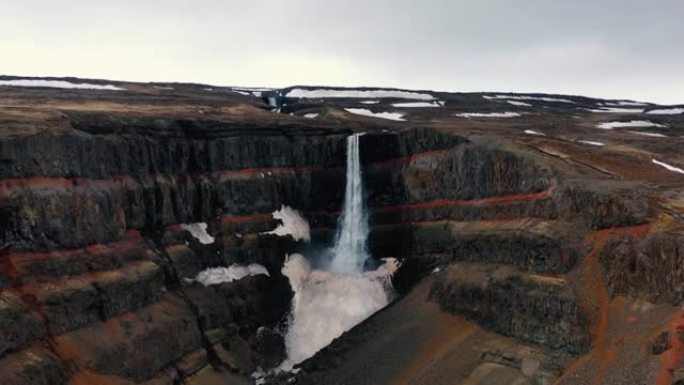 冰岛五颜六色的峡谷环绕的风景瀑布的鸟瞰图